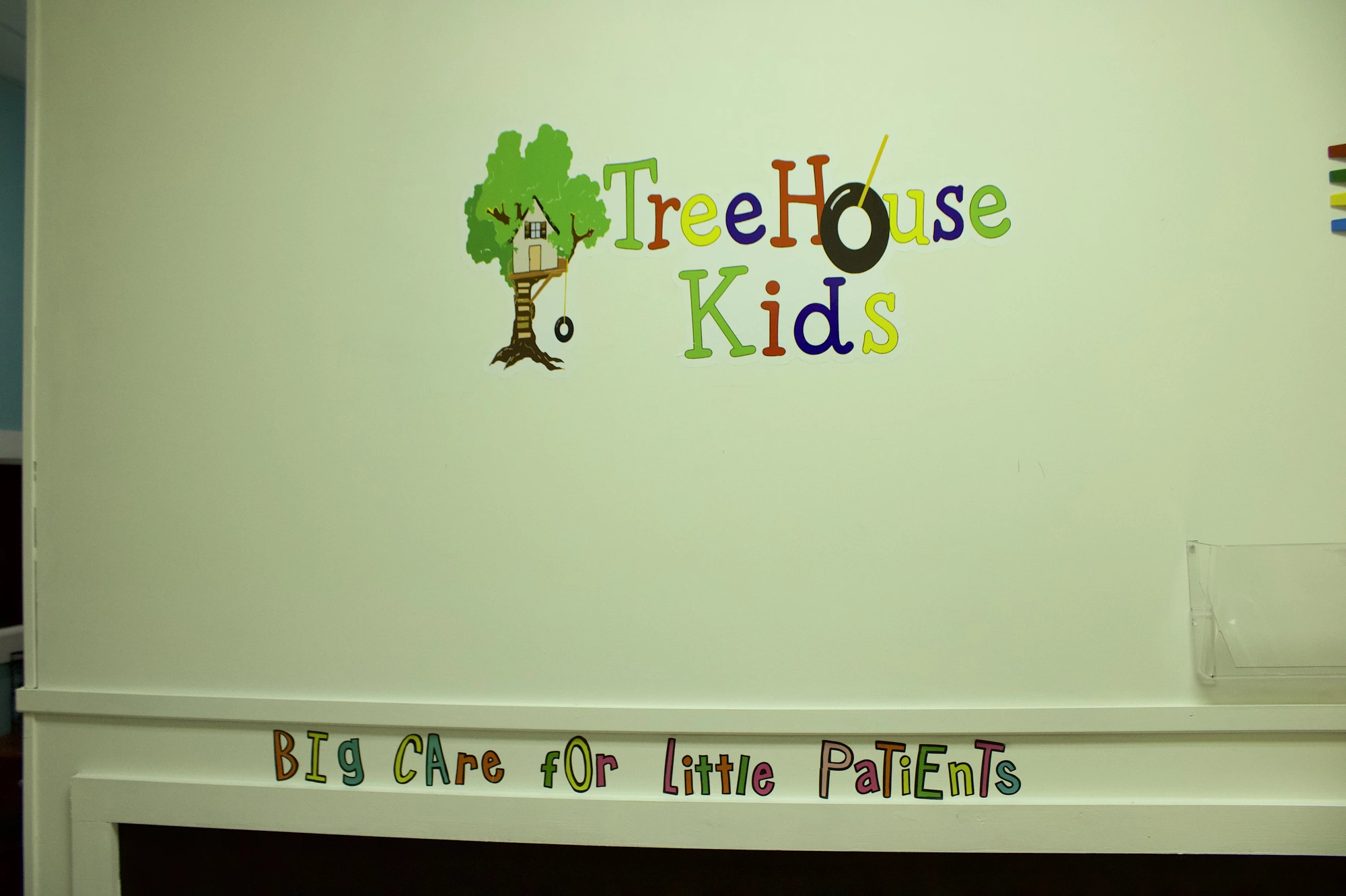 Front desk with colorful TreeHouse Kids mural and 'Big Care for Little Patients' lettering