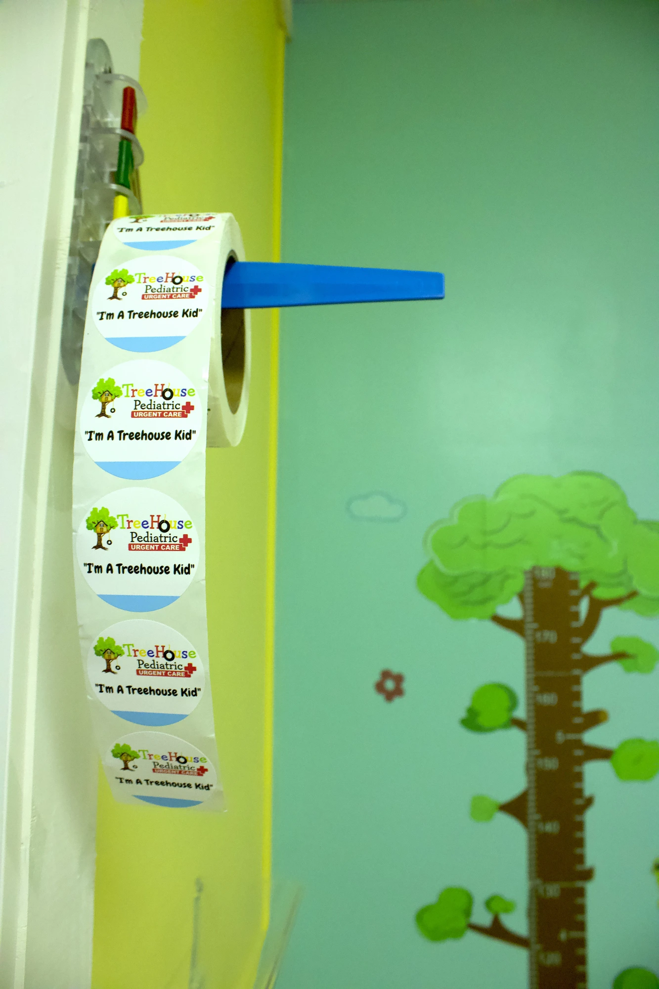 Roll of 'I'm a Treehouse Kid' stickers by a growth-chart tree